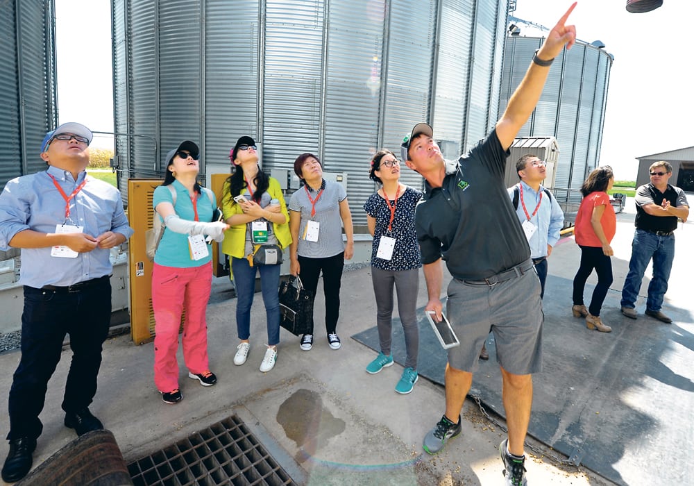 Soybean and corn farmer Marc Kaiser points out features of one of his grain bins to a Chinese trade delegation near Norborne, Missouri, U.S., Aug. 28. Despite his efforts to make his products attractive to Chinese buyers, Kaiser’s soybeans are worth US$2.50 less per bushel than those of other countries in the Chinese market right now.  |  REUTERS/Dave Kaup photo