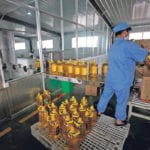 A worker packs bottles of vegetable oil made from U.S. grown soybeans at the Liangyou Industry and Trade Co., plant in Qufu, Shandong province, China. That was July 4. Currently, supplies of beans to crush are reportedly coming from Brazil. | REUTERS / Jason Lee photo