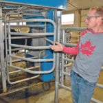 Eric VanderVeen shows one of the new robotic milkers that his family recently added to their dairy farm. Despite the investment, his father, Klaas, says the future of their dairy farm is less secure now that the U.S.-Mexico-Canada Agreement has been signed. | Barb Glen photo