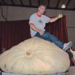 Don Crews’ 1,884 pound site record pumpkin made a great perch for the winning grower. | Les Dunford photo