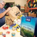 A volunteer at Helping Hands food bank in Steinbach, Man., empties a bag filled with donated items. The food bank feeds hundreds of families in southeastern Manitoba, and a large percentage of the food comes from the FCC Drive Away Hunger campaign. Last year the FCC and local schools collected about 70,000 meals for food banks in southeastern Manitoba. | Robert Arnason photo