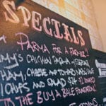 A menu board at the Old Fitzroy Hotel in Sydney, Australia, displays the slogan “Parma for a Farmer,” indicating that the proceeds from sales of parmagiana will go to farmers suffering from drought this year. The extremely dry conditions in eastern Australia are expected to significantly curtail the country’s export potential. | REUTERS/David Gray photo