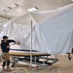 Matt Cole shrink wraps a large boat in the bright spacious shop that used to be a dairy barn. | Maria Johnson photo