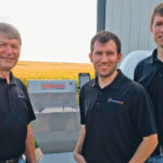 Praxidyn founder Doug Applegate with sons Luke, at left, and Brent focus their energy on developing products like their Mixmate Pro Inductor, in the background, to help streamline the process of filling sprayers. | Doug Applegate photo