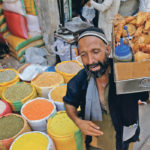 A vendor with a pane of vegetable rolls and samosas, a traditional snack, walks past the sacks of grain and lentils at wholesale market in Karachi, Pakistan, April 2. It once bought 15 percent as much of Canadian pulses as India, now it buys 50 percent due to its neighbour’s reduced purchases. | REUTERS/Akhtar Soomro photo