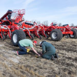 Garth Massie and Mason Kraushar of Morris Industries discuss seed depth for a crop of canola they are seeding at Ag in Motion, May 14. | William DeKay photo