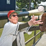 Jane Shury catches a fly ball beside Canada’s Biggest Baseball Bat located at the Saskatchewan Hall of Fame and Museum in Battleford, Sask. | William DeKay photo