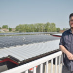 Greg Robinson, director of community and economic development for the Town of Raymond, stands near an array of solar panels on the town’s stadium. The town has put solar panels on almost all the municipally owned buildings and is the first town in Canada and possibly in North America to be electrically net zero. | Barb Glen photo