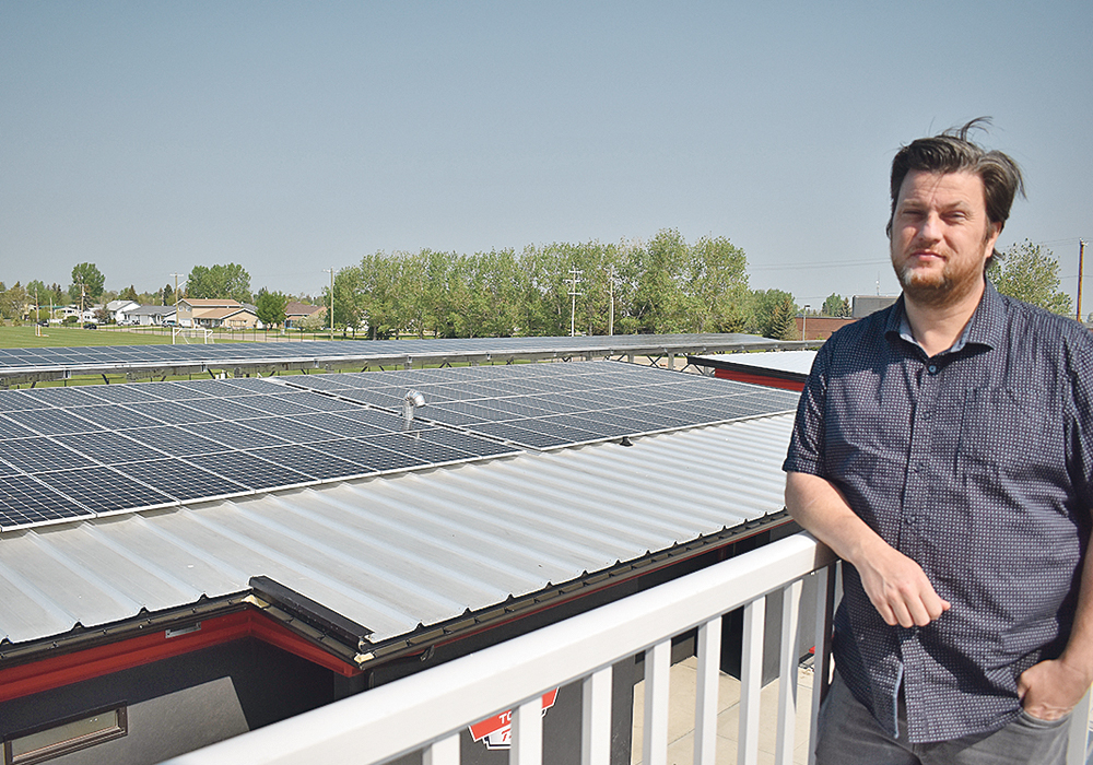 Greg Robinson, director of community and economic development for the Town of Raymond, stands near an array of solar panels on the town’s stadium. The town has put solar panels on almost all the municipally owned buildings and is the first town in Canada and possibly in North America to be electrically net zero.  |  Barb Glen photo