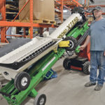 Darren Grose shows Rodono’s newly developed product, the retracting transfer conversion kit. It is an add-on to existing air seeder cart augers or belts and adds the functionality to extend and pivot under a hopper bottom trailer. | Maria Johnson photo