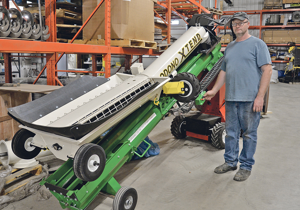 Darren Grose shows Rodono’s newly developed product, the retracting transfer conversion kit. It is an add-on to existing air seeder cart augers or belts and adds the functionality to extend and pivot under a hopper bottom trailer.  |  Maria Johnson photo