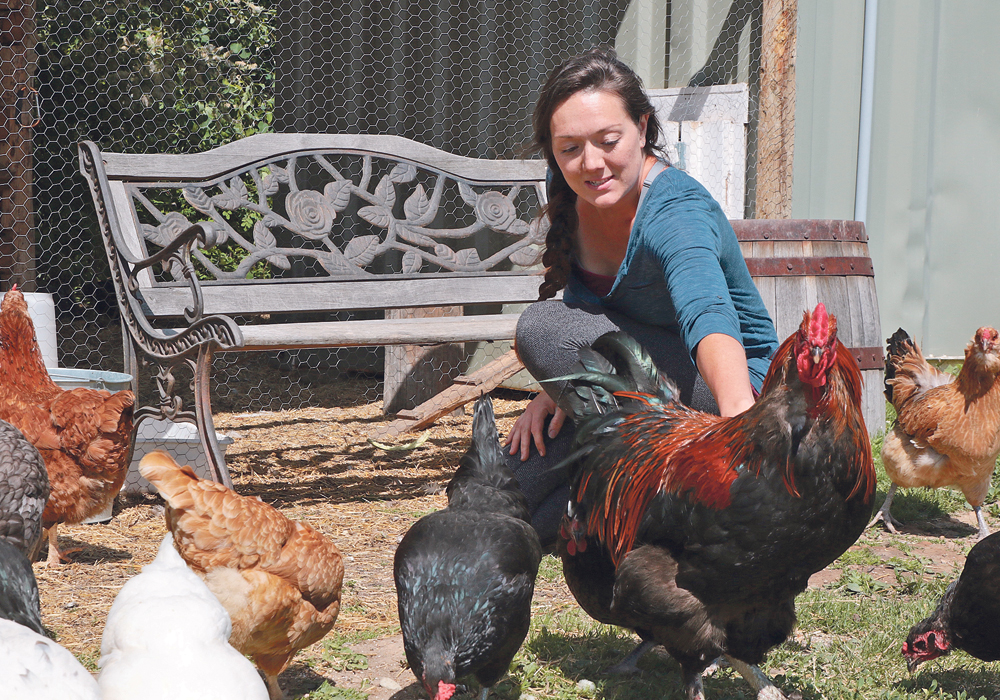 Katy Peck visits with the chickens on her farm near Charlie Lake, B.C.  |  Jeremy Simes photo