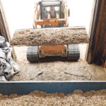Wood chips are a key component of Titan Clean Energy Projects’ charcoal program. Here, they are being loaded into the in-feed hopper. | William DeKay photo