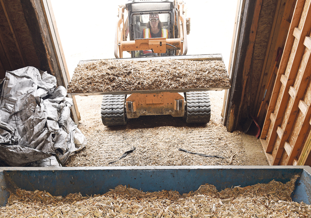 Wood chips are a key component of Titan Clean Energy Projects’ charcoal program. Here, they are being loaded into the in-feed hopper.  |  William DeKay photo