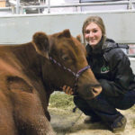 Brynne Yoder of Cinder Angus hangs out with her winning grand champion female at Farmfair. | Jeremy Simes photo