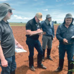 Tom Greene, left, works with breeders across the globe to improve crop genetics. Here he is in Brazil with colleagues observing plots firsthand. | Corteva photo