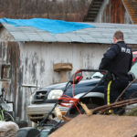 A RCMP officer examines a rural property in the St. Paul, Alta. area. | Jeremy Simes photo