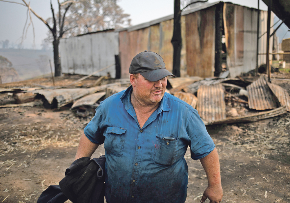 Tim Salway, a fifth-generation dairy farmer who lost both his father and brother in the bushfires, stands in his farm in Wandella, near the town of Cobargo, New South Wales, Jan. 13. Much of Salway’s farm was destroyed by bushfires, including storage facilities, fences and hundreds of cattle. | REUTERS/Alkis Konstantinidis photo