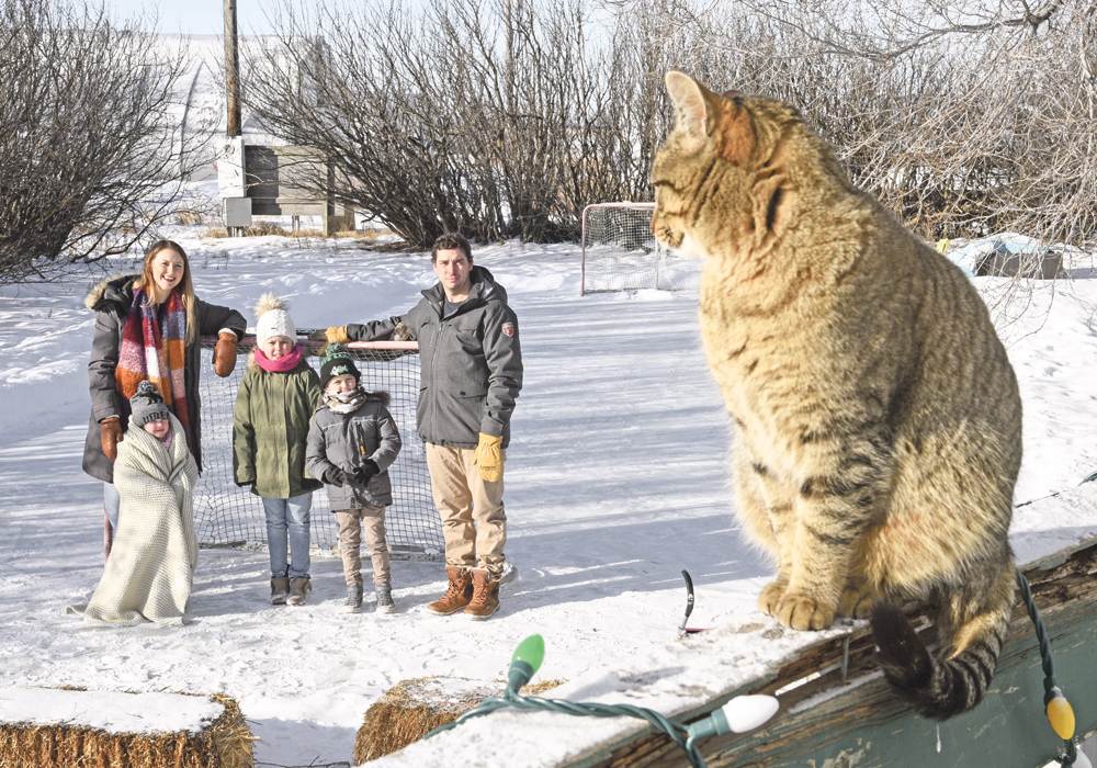 Chelsea, left, Lainey, Calla, Raulan and Dan Erlandson enjoy their homemade hockey rink at Spring Creek Garden north of Outlook, Sask.  |  William DeKay photo