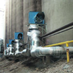 AirLanco clockwise downblast centrifugal fans push air into the manifold’s ductwork. The fans were mounted above the ductwork to allow for more space between them and the road. The ductwork system carries the air from the fan to each Air Auger run inside the tank. Each run has a butterfly valve in the ductwork that is to be opened and closed as need for aeration of the bin or unloading of the bin. | AirLanco photo