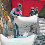 Workers carry aid provided by the World Food Program for distribution in Pissila, Burkina Faso, in January. | Reuters/Anne Mimault photo