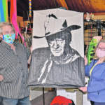 Bud Taylor and Sharon Musto run a kite shop in central Alberta. Musto made this John Wayne kite for Taylor as a gift. The kite style is Ohashi variant and flies without a tail. It is based on a design by Japanese master kite builder Eiji Ohashi. The couple’s shop is open to the public on an appointment basis, and they follow the recommended protocols, including wearing masks. Note that Taylor’s mask is a made out of a bright kite-themed fabric. | Maria Johnson photo