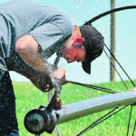 Pete Hiebert fixes a malfunctioning end gun on a wheel move irrigation system near Diamond City, Alta., June 25. It was a hot day, so a little cool spray from the irrigation system was not unwelcome. | Barb Glen photo