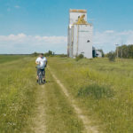 Mark Kihn stands in front of an old grain elevator at Clanwilliam, Man., which is no longer standing. | Brian Nicholls photo