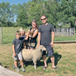 Josh, left, Bohdan, Anna and Luke hang out with some of their sheep.