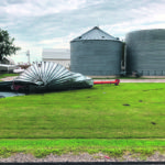 A grain bin damaged by the derecho, a fierce wind that swept through central Iowa Aug. 10, lies in a farmyard. | USDA/Jeremy Davis photo