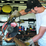 Corey Clark cuts steel fence posts from 2 7/8 inch tubing in preparation for an expansion of the existing corral system at Shady Nook Farm. | Maria Johnson photo