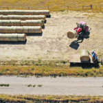Logan Vanderploeg unloads Cam Ostercamp’s horse-down hay wagon. | Mike Sturk photo