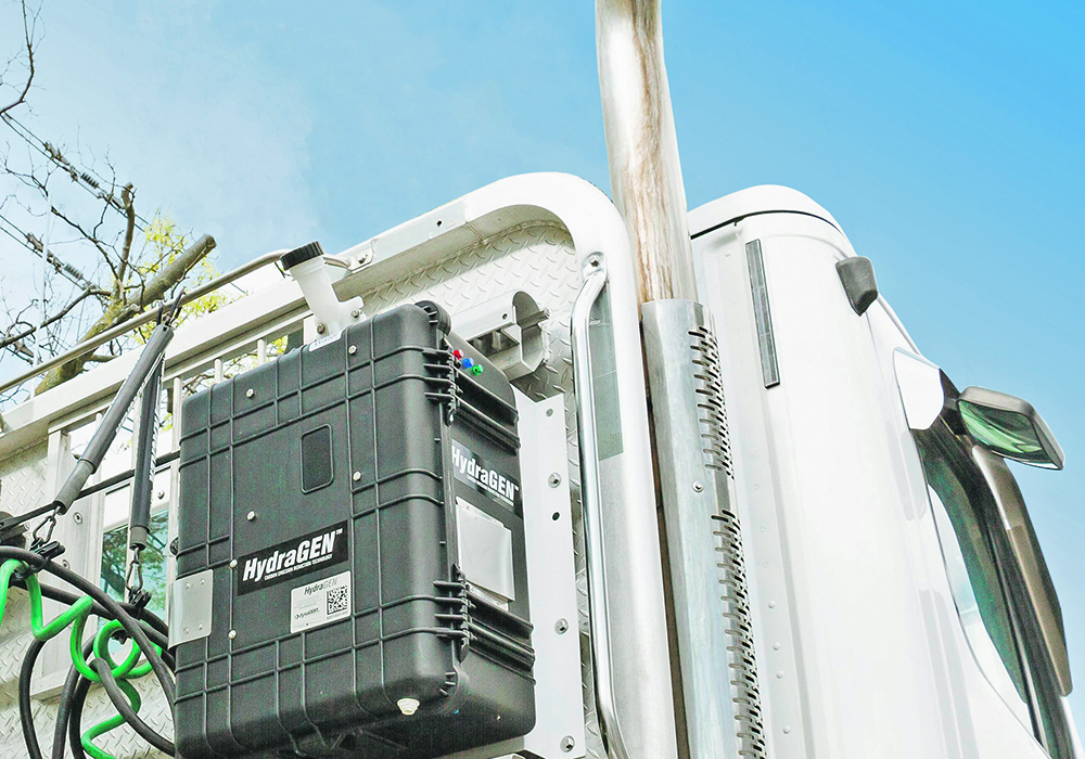 The cab-mounted suitcase can reduce fuel consumption by 20 percent on this over-the-road tractor. The HydraGEN box contains equipment to convert distilled water into pure hydrogen and pure oxygen, which are then directed into the air intake, where they create a cleaner burn.  |  Dynacert photo