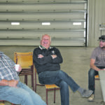 Saskatchewan agriculture minister David Marit, centre, looks comfortable while visiting with Kevin Antworth, left, manager of Red Coat Cattle Feeders, and Preston Dorgan during a campaign stop at Garth Dorgan’s farm shop in Meyronne, Sask., Oct. 7. | Karen Briere photo