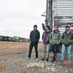 A Canadian National Railway train rumbles by Fusarium band members Owen Gerrard, left, Mike Vidal, Brett Arnelien and Darian Dutchak. The sights and sounds around the Asquith, Sask., grain elevator provide band members with inspiration for their music, song writing and recordings. | William DeKay photo