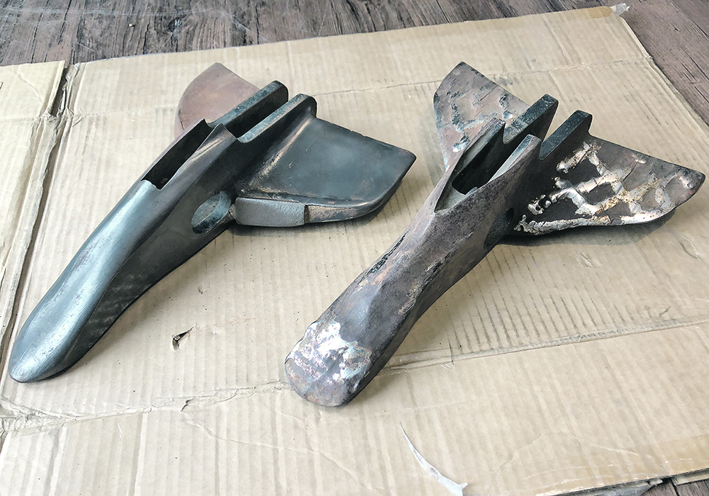 The opener on the right  was hard surfaced on the nose and wings ran for 160 acres, was hard surfaced again and after 160 acres is too worn to fix, as the tip no longer digs into the soil and wings are worn thin. At left, Ferobide tiles have protected the wings and nose for 1,500 acres.  |   Huber Ag Equipment