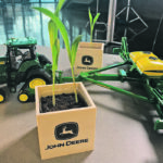 Simulation of planting puts technology journalists into the soil, so they can experience farming close up. And gives them seeds to plant, to better understand what it takes to produce a crop. | Jenny Ose/Deere photo
