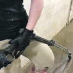 A strap attaches the pressure washer wand to a worker’s wrist. If the worker loses control of the wand, the mechanism automatically disengages the trigger. | Agri-Marche photo