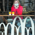 A woman sits inside a McDonald’s restaurant in Kiev, Ukraine, last fall. The company surprised analysts in November with higher sales and profitability than expected following the slump of the first months of the pandemic. Its net sales dropped only two percent from the previous year. | Reuters/Valentyn Ogirenko photo