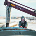 Logan Vanderploeg of Circle D Trucking checks a load of Dan Nauta’s canola from bins east of Blackie, Alta. The canola will be trucked to the Richardson Pioneer grain elevator in Carseland, Alta. International demand for Canada’s crop continues to increase. | Mike Sturk photo