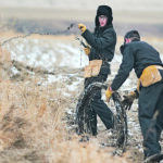 Ted Waldner, left, frees barbed wire from a fence post while Steven Waldner rolls it up. | Mike Sturk photo