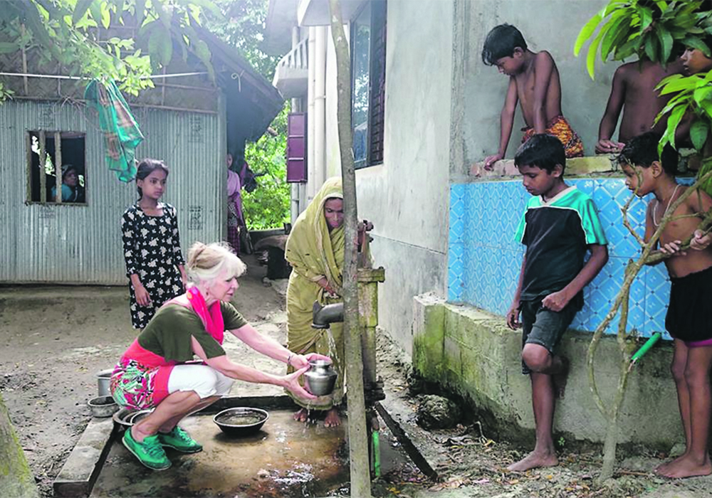 Judit Smits from the University of Calgary’s faculty of veterinary medicine collects water with a villager in Bangladesh. | University of Calgary photo