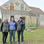 Betty Ann, Jentre and Francois Brault of Wetaskiwin, Alta., stand in front of their gift shop home. The house was built in 1914 and was where Betty Ann was raised and where she and Francois lived when they were first married. | Mary MacArthur photo