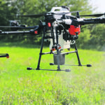 The DJI Agras T20 drone sprays water as part of an in-crop demonstration. The rotors force the spray to a wide width. | Mary MacArthur photo