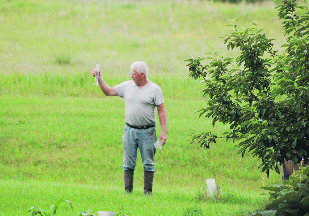 Hugh Greaves checks the rain gauge on his farm near Deerwood, Man., on the June 26-27 weekend. Five millimetres was all that a slow leisurely rain delivered, but it provided some reprieve to the crops. | Jeannette Greaves photo