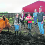A Red Angus keeps an eye on the the Skinner family at home on the farm: Bonnie, Alice, 10, Sarah, 12, Ruben, 6, and Pat. | William DeKay photo