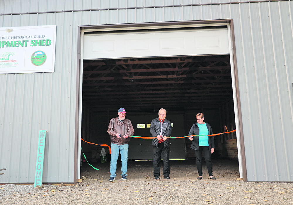 Harvey Hagman, centre, chair of UFA’s Rural Communities Foundation, cuts a ribbon for the Onoway and District Historical Guild along with Brian Turnbull and Hazel Bourke of the guild. The organization received a $50,000 grant in 2019 from the Rural Communities Foundation to build its equipment shed to house the museum’s artifacts, including tractors and threshing machines. The shed is part of a larger plan to create an historical village, complete with threshing demonstrations to ensure the past is remembered. | Mary MacArthur photo
