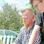Todd and Jack Rennebohm look at the book Todd wrote to help children cope when their parents deal with mental health challenges. | Christalee Froese photo
