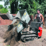 Nic Guran of Legacy Yard Works empties a load of topsoil from the Raupen Dumper RC 800 at a Saskatoon yard. The unit was brought in through the usual gate, eliminating the
need to dismantle fence panels. | Michael Robin photo
