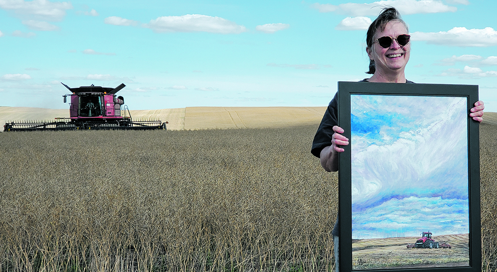 Jill Mitchell, a project ambassador with Grow Hope Saskatchewan, holds the painting, “Feeding the World — One Grain at a Time” that was auctioned off during harvest at the 
charity’s project near Bruno, Sask. | Mennonite Central Committee photo
